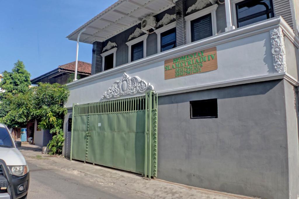 un bâtiment avec une porte verte sur le côté d'une rue dans l'établissement OYO Life 92830 Homestay Slamet Riadi Iv, à Bandar Lampung