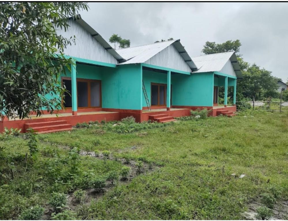 uma casa num campo ao lado de um quintal em Mayuri Nature Camp, Barangabari, Assam em Jyoti Gaon