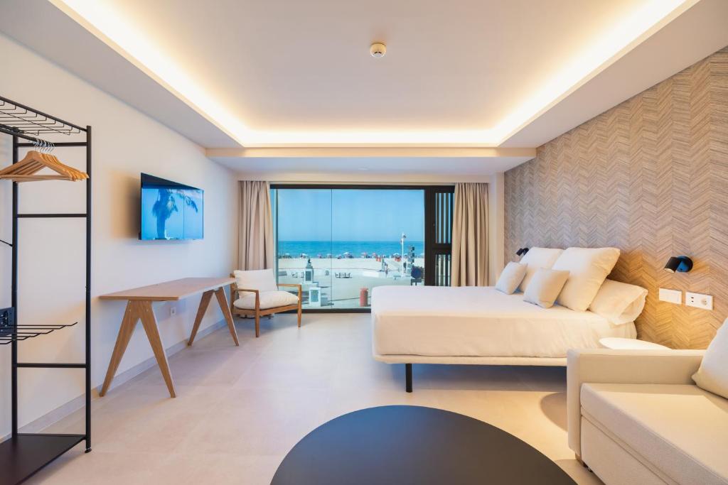 een slaapkamer met een bed en een woonkamer bij Apartamentos Playa Victoria in Cádiz