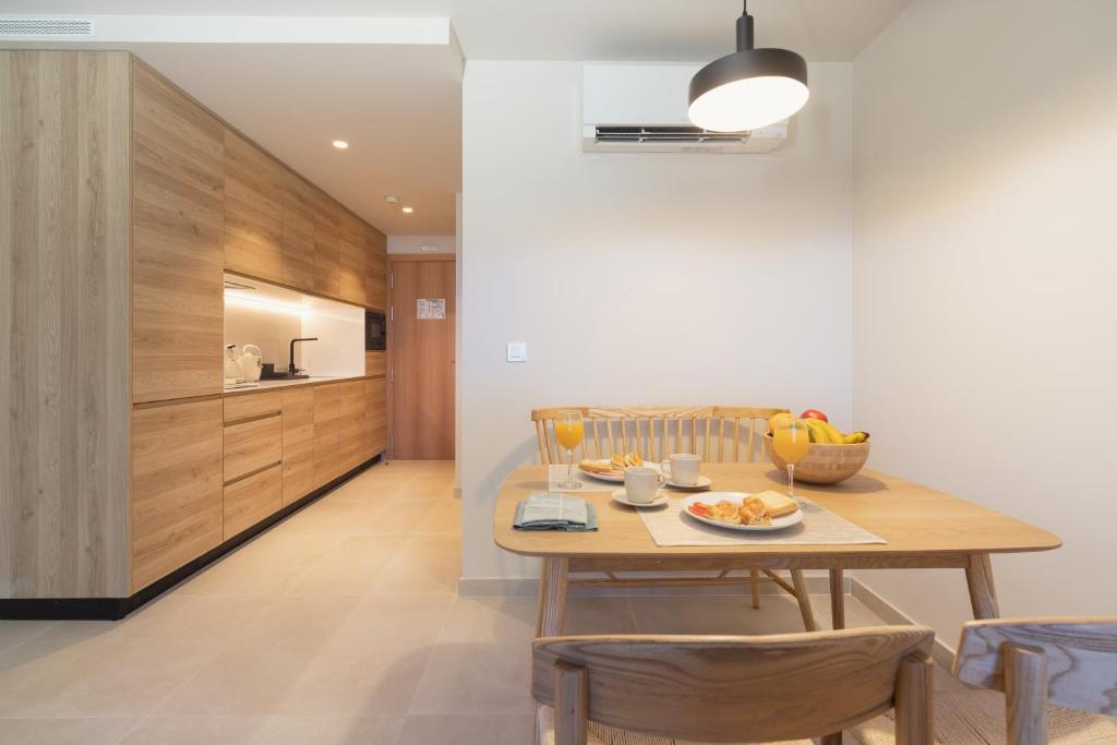 a kitchen and dining room with a table and chairs at Apartamentos Playa Victoria in Cádiz