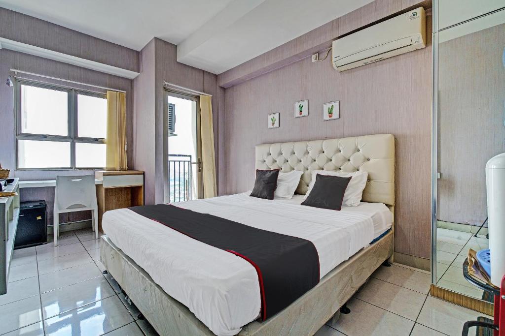 um quarto com uma cama grande e uma casa de banho em OYO Life 92548 M-square Apartment By Lins Pro em Bandung