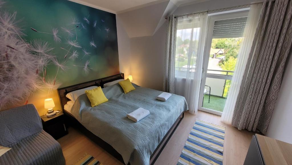 um quarto com uma cama com almofadas amarelas e uma janela em Pitypang Apartman*** em Zalakaros