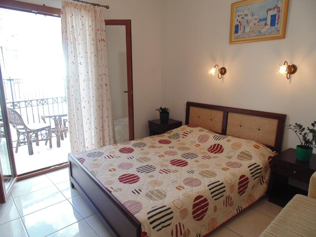 1 dormitorio con cama con colcha en Maria Studios, en Skiathos