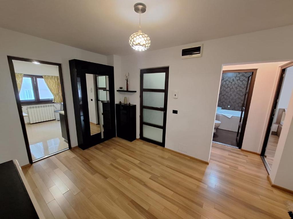 uma sala de estar com duas portas e um piso de madeira em Urban George Enescu 4 BeedRoom Apartment Suceava em Suceava