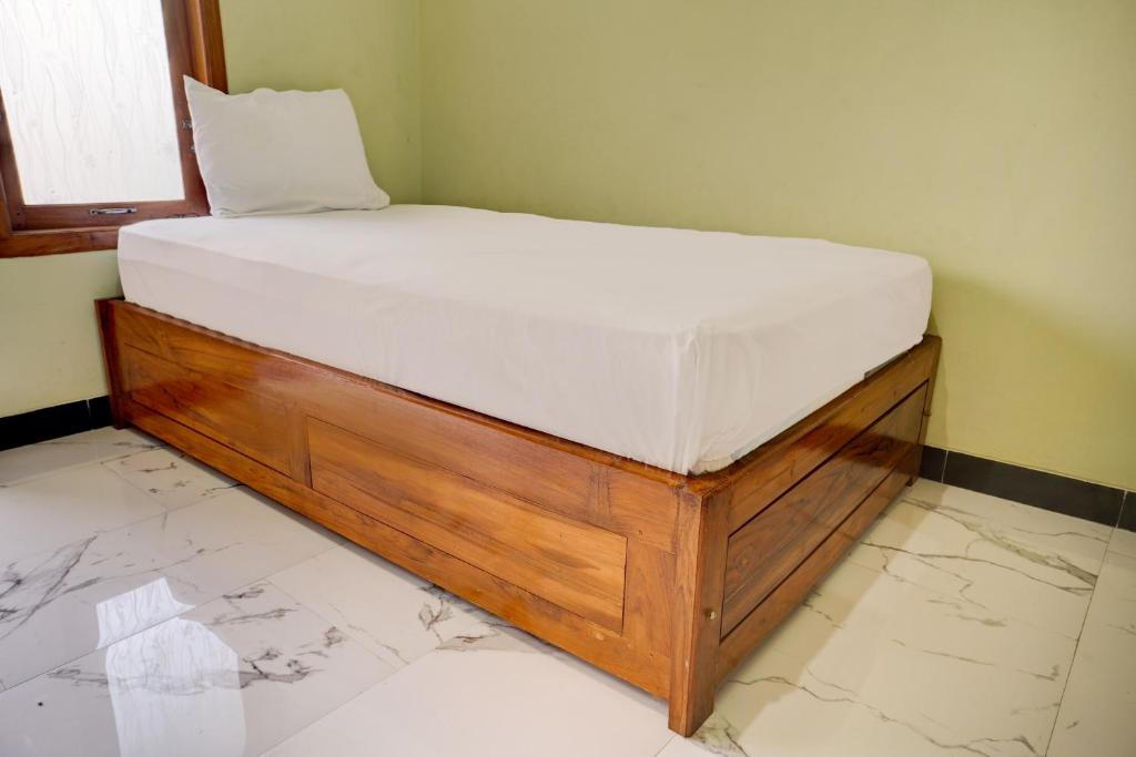 een bed in een hoek van een kamer bij OYO Life 92922 Kost Bu Mala 1 Syariah in Pasuruan