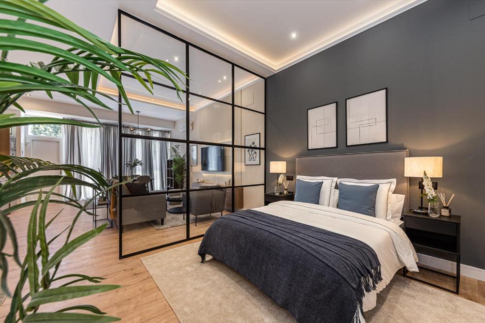 een slaapkamer met een groot bed en een grote plant bij Exyca Embajadores in Madrid