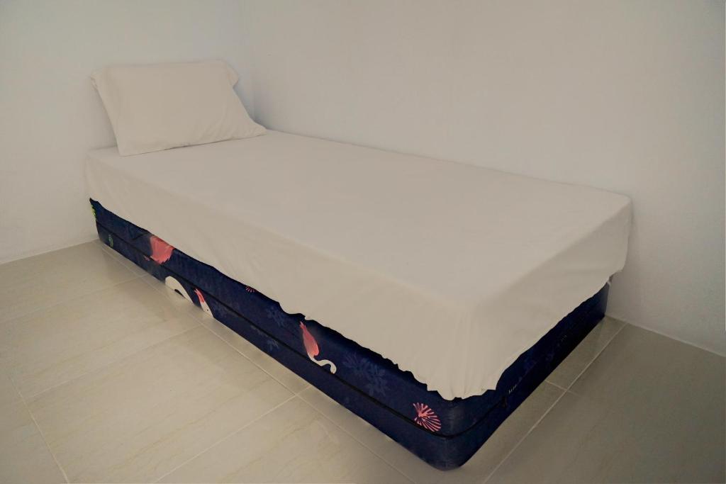 uma cama num quarto com um colchão branco em OYO Life 92918 Rumah Kost Arrahma Syariah em Nganjuk