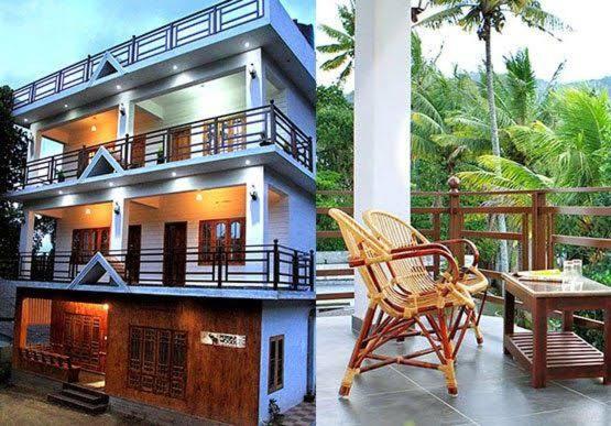 a house with two chairs and a table on a balcony at Periyar Heritage in Thekkady
