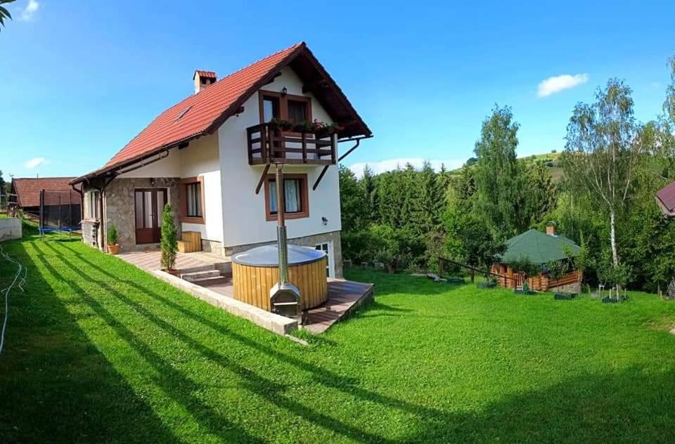 a house with a large yard with a green lawn at Apple Glade in Poiana Mărului