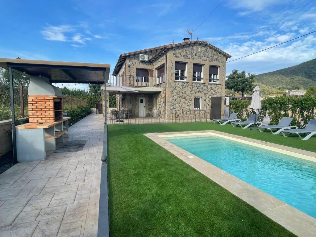 une villa avec une piscine et une maison dans l'établissement Ca la Joia Casa con piscina privada en la Vall d'en Bas, à Les Preses