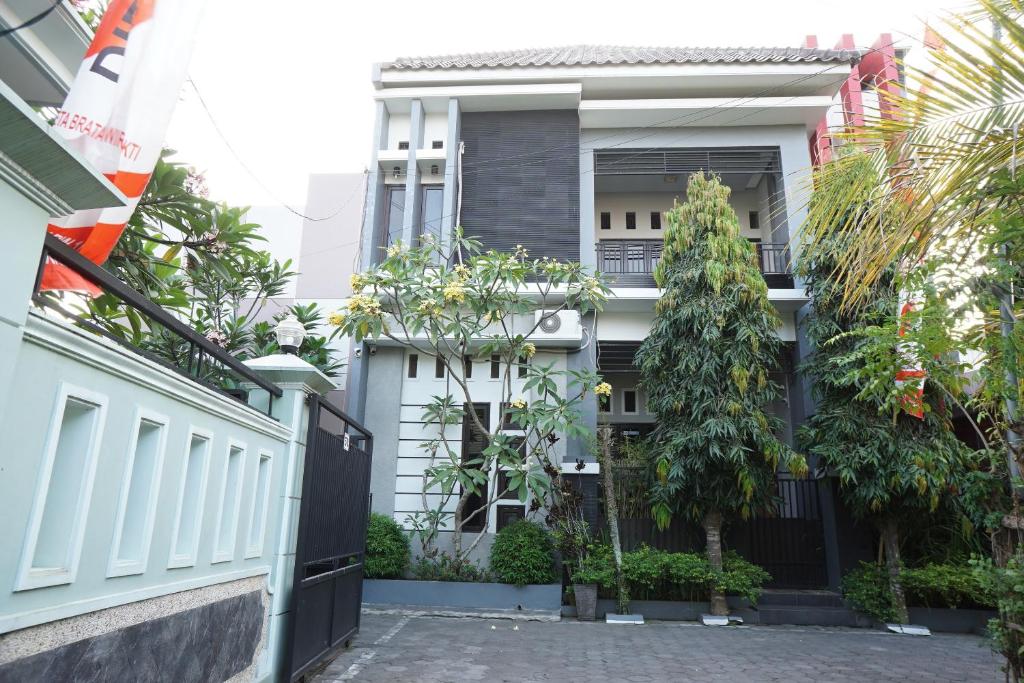 een huis met een poort en bomen ervoor bij OYO Life 93045 Kost Putra Bu Ketut in Lumajang
