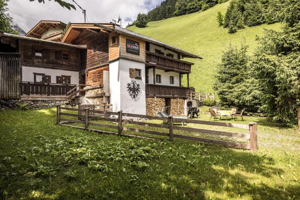 una casa su una collina con una recinzione di fronte di Alpenzauber / Chalet AlmZeit / Almhütte Zillertal a Schwaz