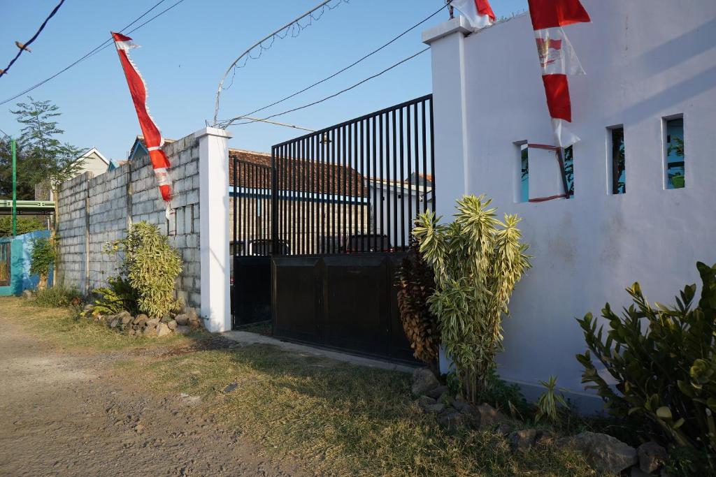 a black gate on a white wall next to a house at OYO Life 93017 Kost H Soeroso in Situbondo