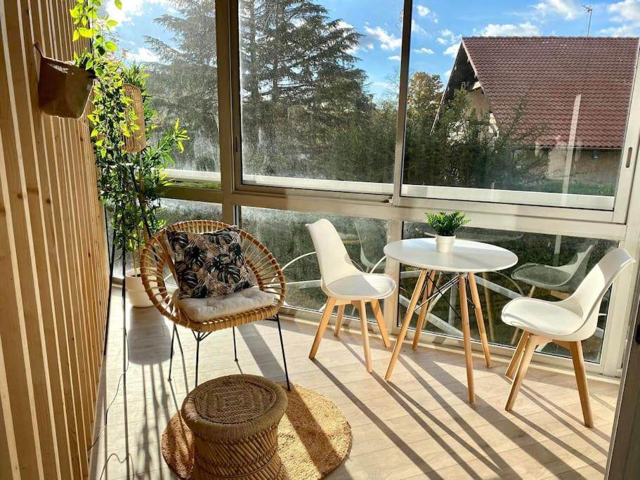 einen Balkon mit Stühlen, einem Tisch und einem Fenster in der Unterkunft The Jungle Studio, loggia & parking dans résidence in Romans-sur-Isère