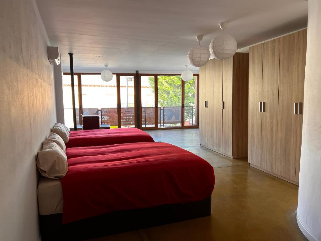 a bedroom with a red bed and wooden cabinets at Muy Céntrico y Amplio in Alcázar de San Juan