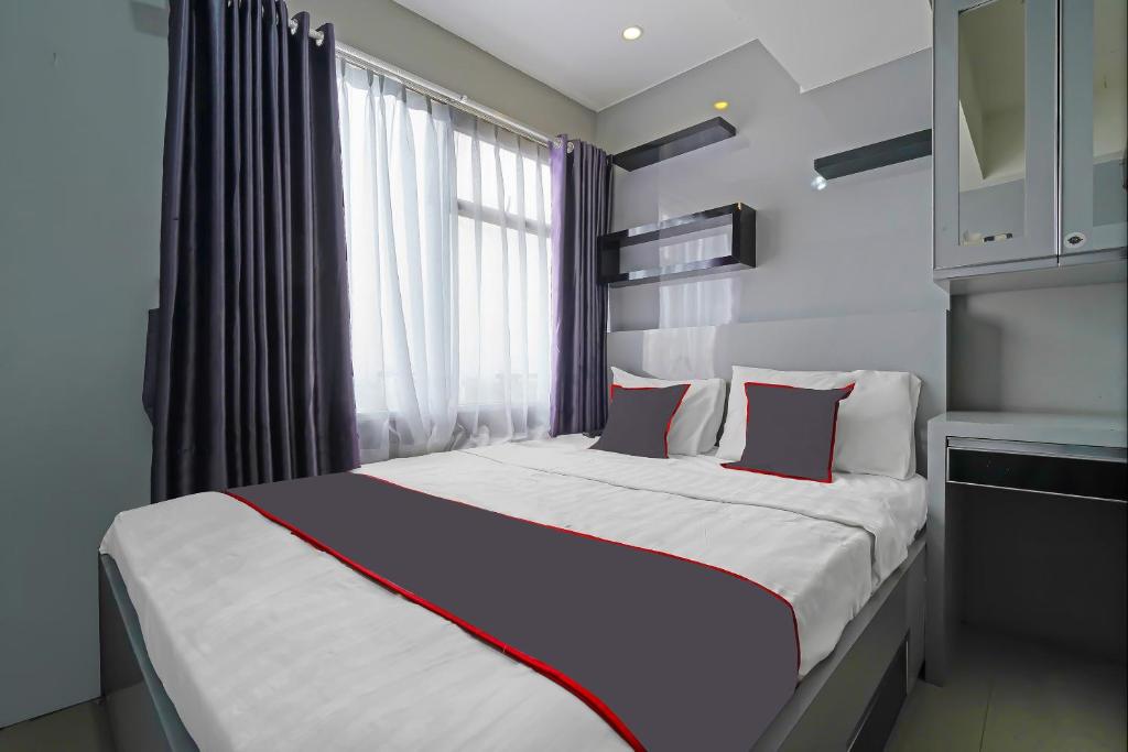 a bedroom with a large bed with a window at OYO Life 92649 Jarrdin Apartment By Glory in Bandung