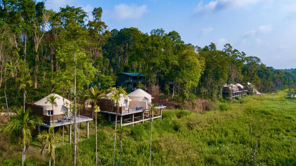 an aerial view of a group of houses in a field at Machaan Wilderness Lodge Nagarahole in Srimangala
