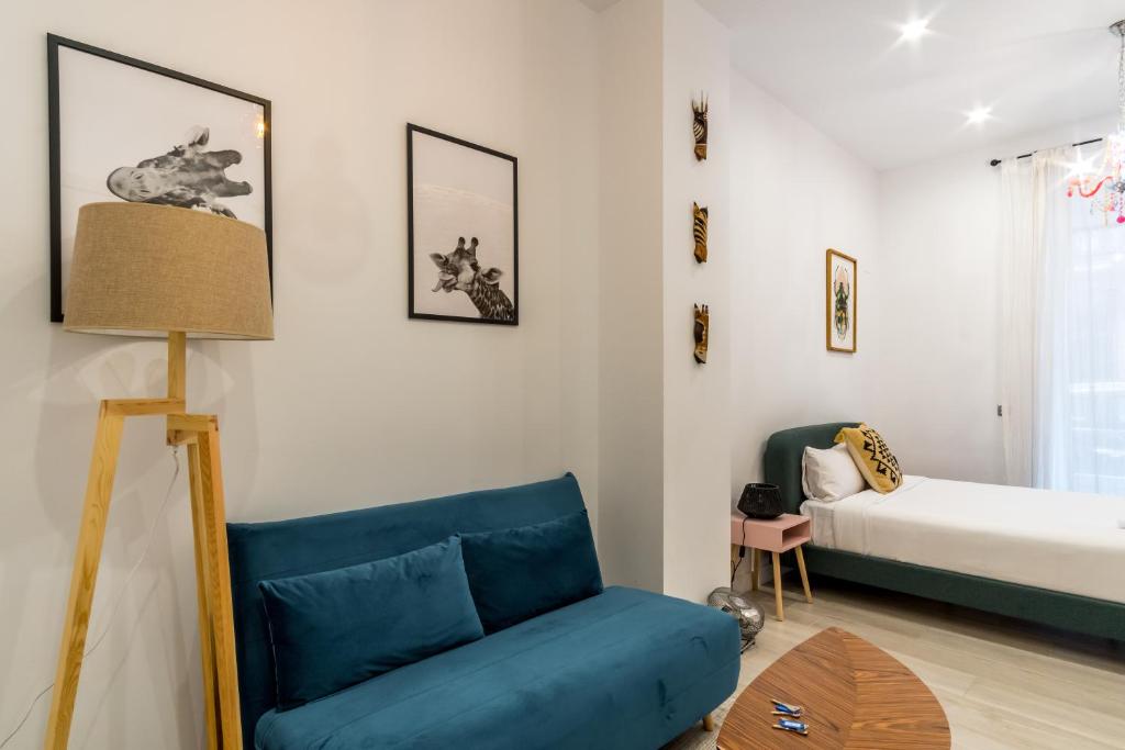 ein Wohnzimmer mit einem blauen Sofa und einem Bett in der Unterkunft 2 habitaciones 2 baños- Moderno y Acogedor - Imperial in Madrid