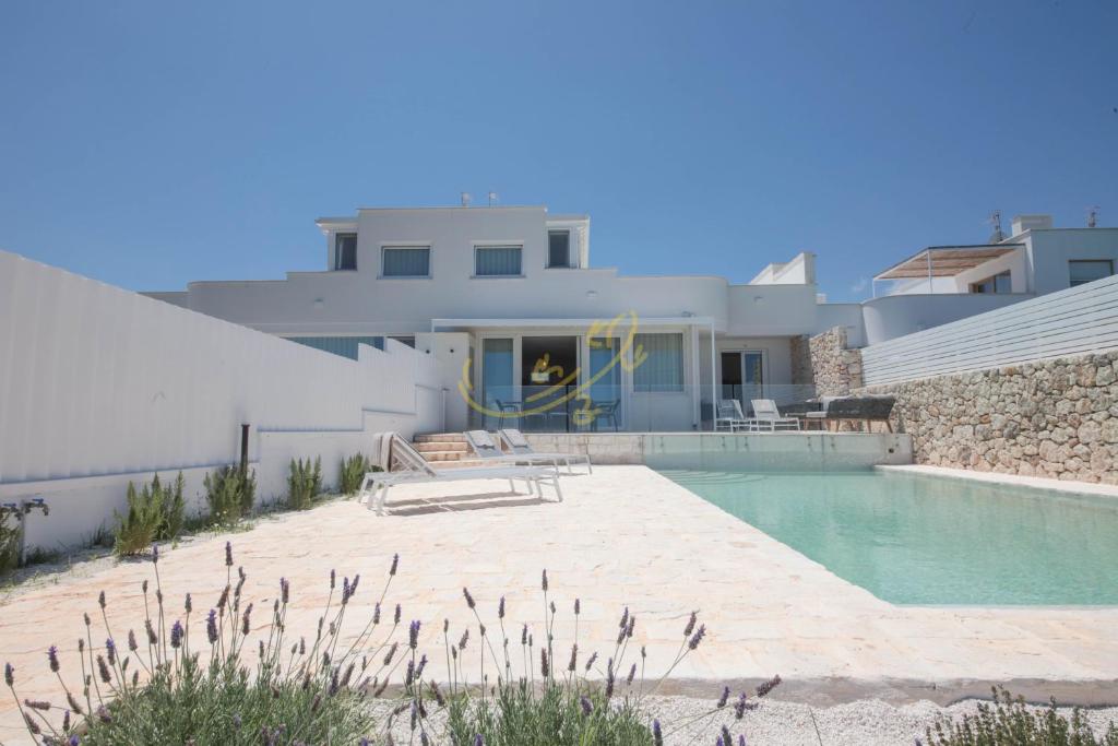 a villa with a swimming pool and a house at TD Villa Grecale Modern Luxury Villa with SeaView in Capitolo