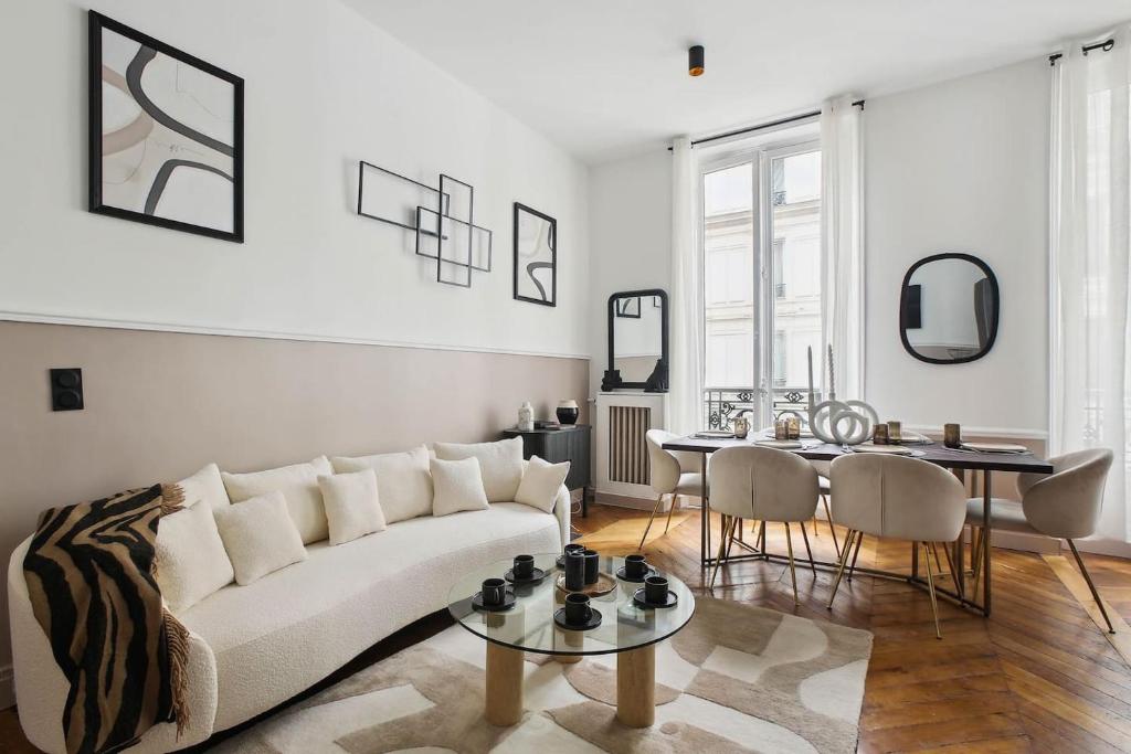 un salon avec un canapé blanc et une table dans l'établissement Champs Elysées luxury 3 bed room, à Paris