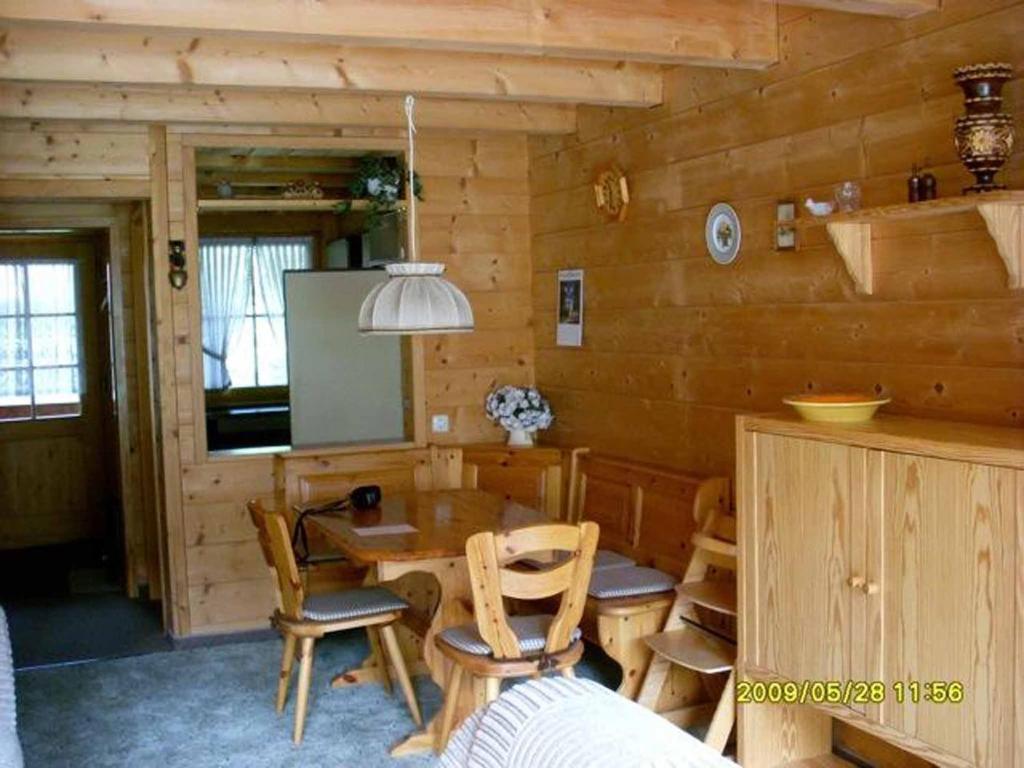 - une salle à manger avec une table et des chaises dans une cabine dans l'établissement Feriendorf Reichenbach - Biberweg 9, à Nesselwang
