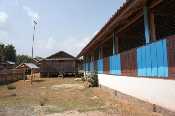 un grand bâtiment avec des tons bleus et bruns dans l'établissement Ban Na Pia - Family Home stay, à Muang Phônsavan