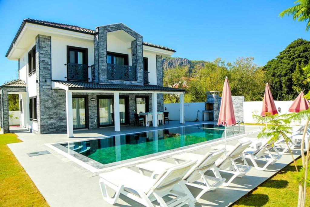 una villa con piscina y tumbonas en Villa Emirhan Dalyan 4 bedrooms, en Dalyan