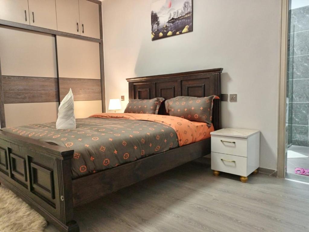 um quarto com uma cama grande e uma mesa de cabeceira em New 2 & 3 bedroom Apartment in Kilimani Nairobi with rooftop pool em Nairobi