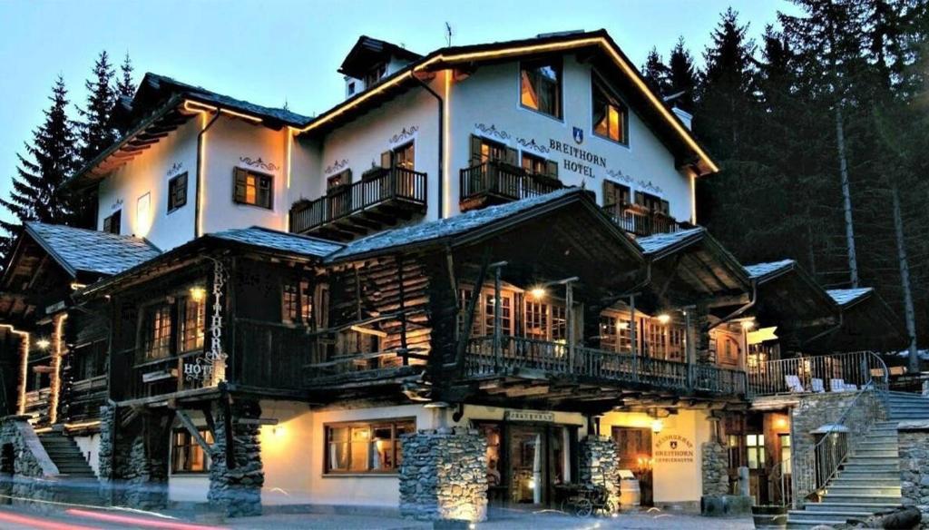 a large wooden building with lights on it at Hotel Breithorn in Champoluc
