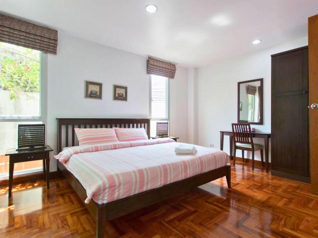 a bedroom with a bed and a table and a chair at P.K. Garden Home in Bangkok