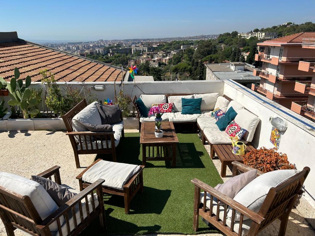 a patio with chairs and couches on a roof at Residenza Parco Gioeni in Catania