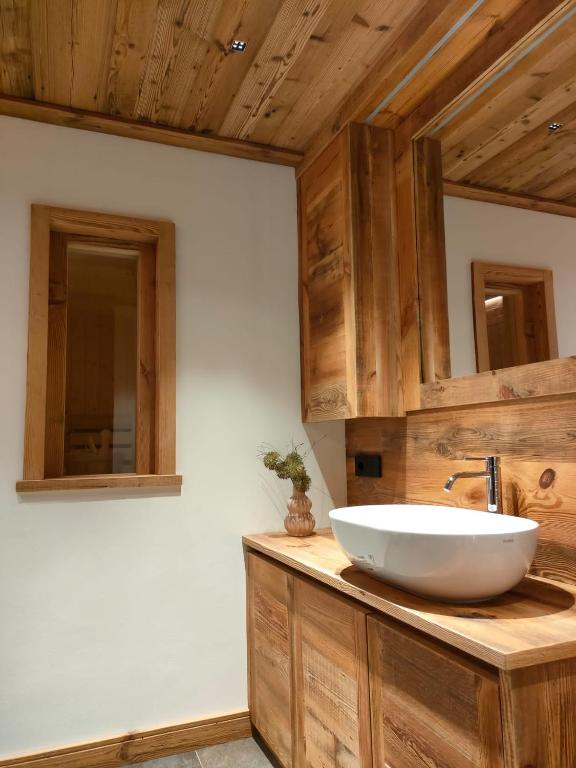 a bathroom with a white sink on a wooden counter at Fior di Roccia Apartments- in centro Cervinia, sauna privata, Matterhorn dream in Breuil-Cervinia