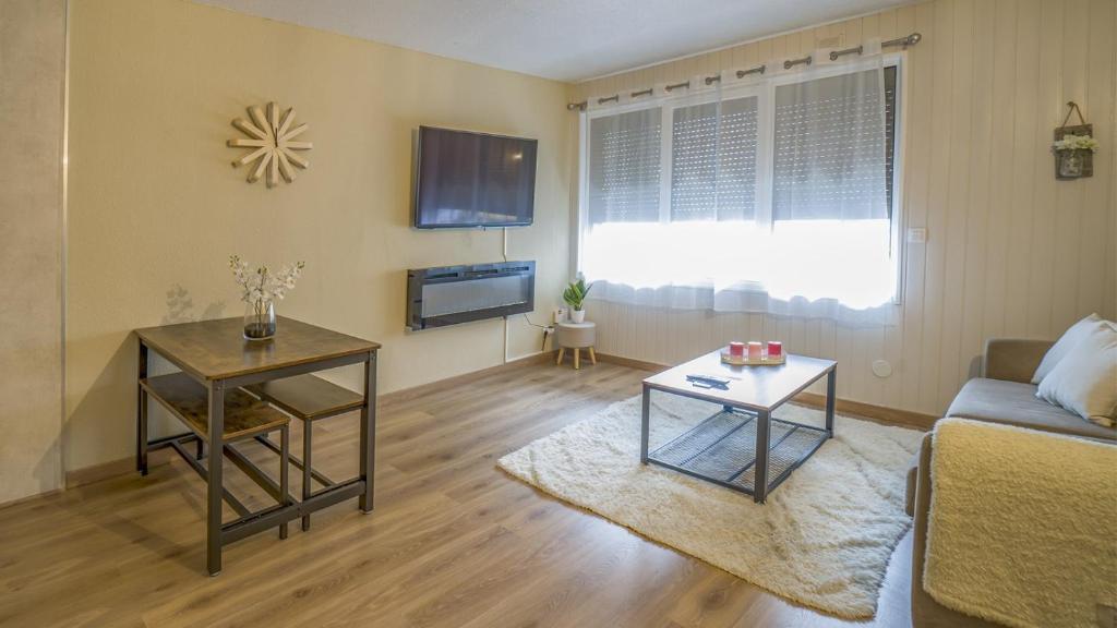ein Wohnzimmer mit einem Sofa und einem Tisch in der Unterkunft NEUF & MODERNE 35m2 - 100 mètres des pistes de ski in Pas de la Casa