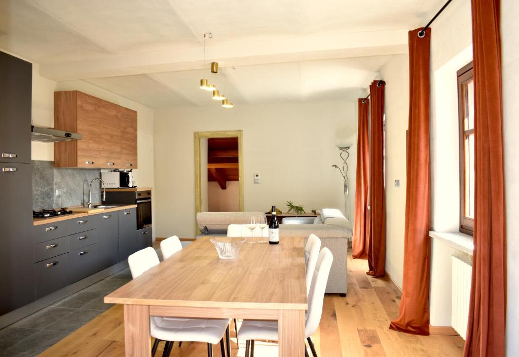 a kitchen and dining room with a wooden table and chairs at Ca' Ronzini in Castiglione Falletto