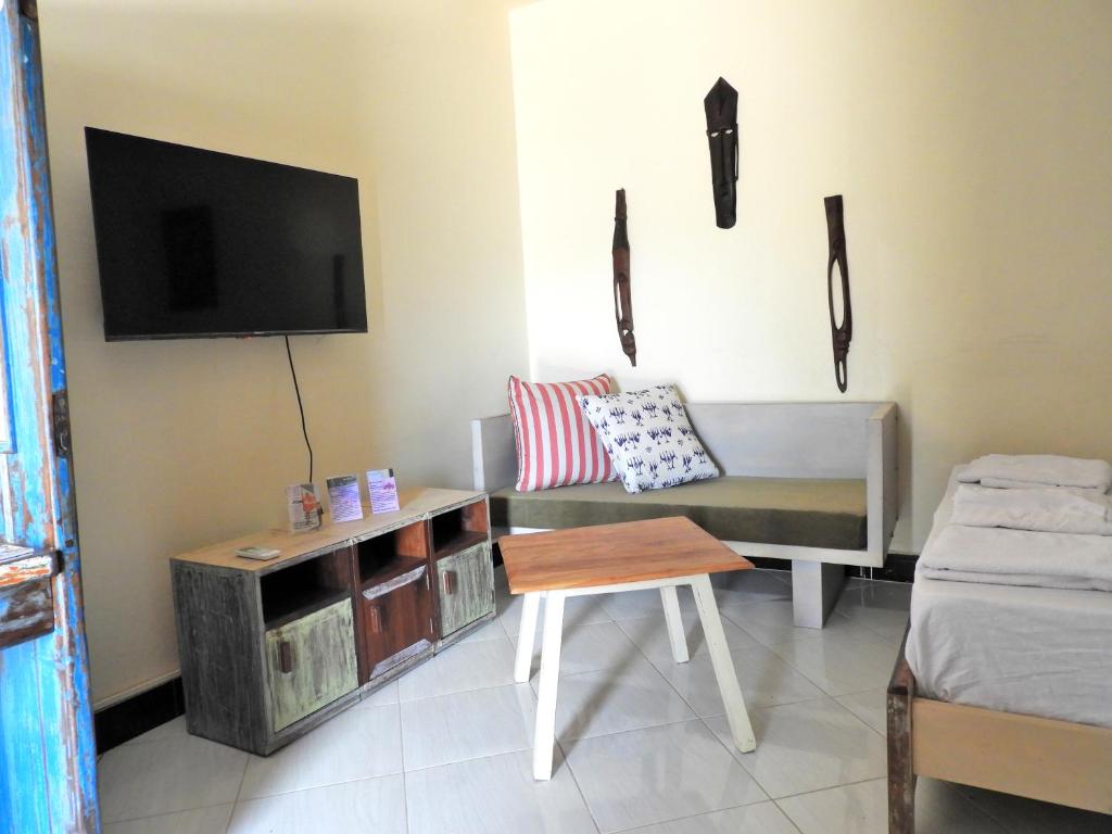 a living room with a couch and a tv at Jogoo rooms in Dar es Salaam