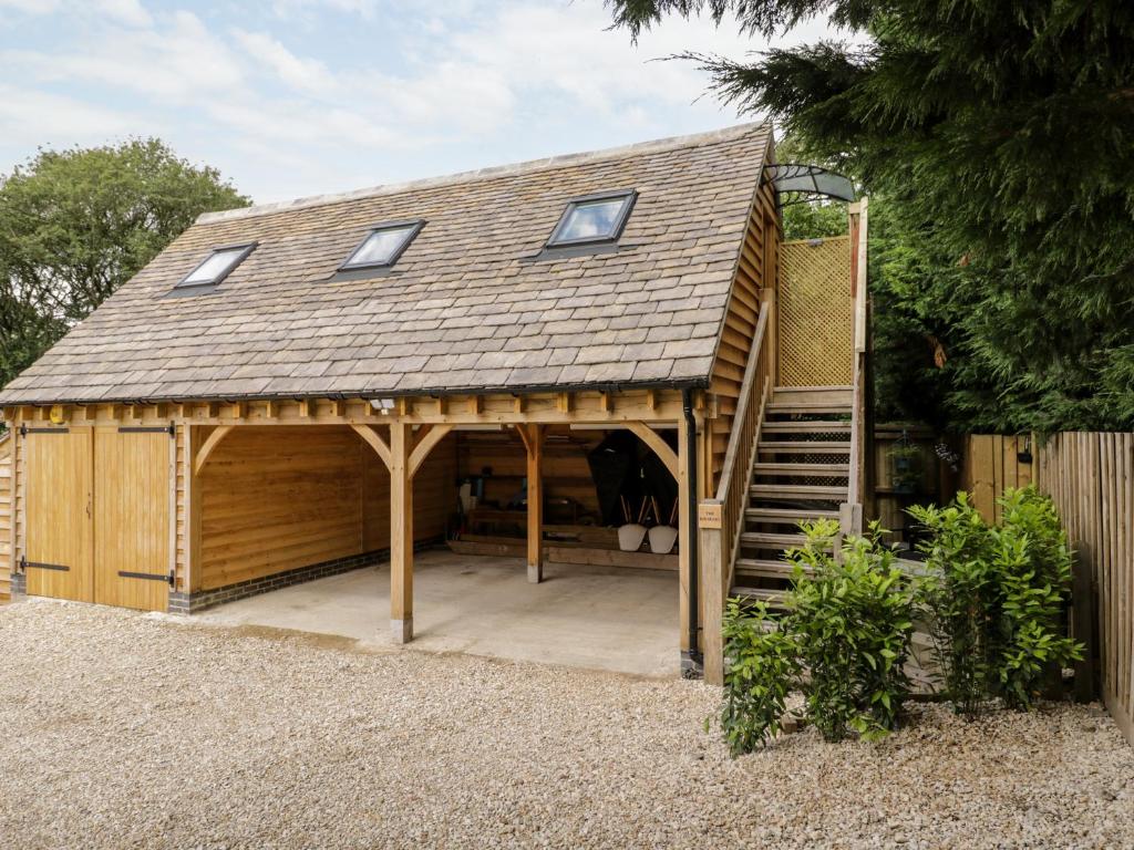 a large wooden building with a roof on top at The Rookery in Burford
