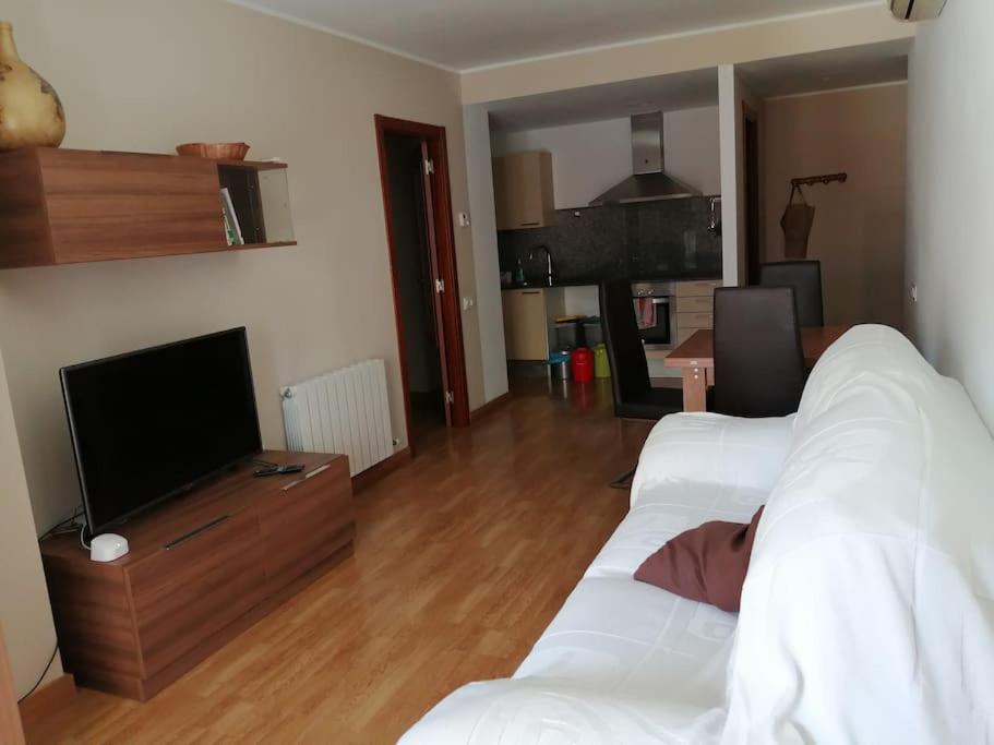 uma sala de estar com um sofá branco e uma televisão em Pis a Bellpuig em Bellpuig
