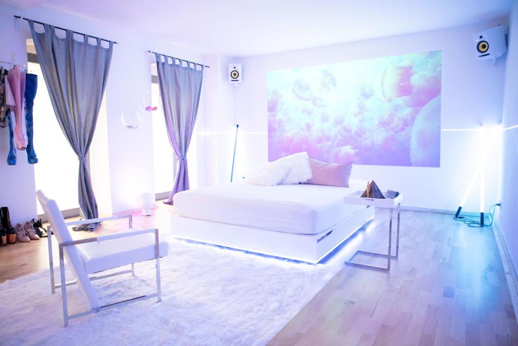een slaapkamer met een wit bed en een schilderij aan de muur bij Cosy Apartment at Prenzlauer Berg with Terrace and HeadphoneCinema in Berlijn
