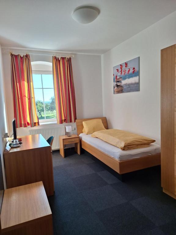 Schlafzimmer mit einem Bett, einem Schreibtisch und einem Fenster in der Unterkunft Gasthaus Kloibhofer in Neukirchen bei Lambach