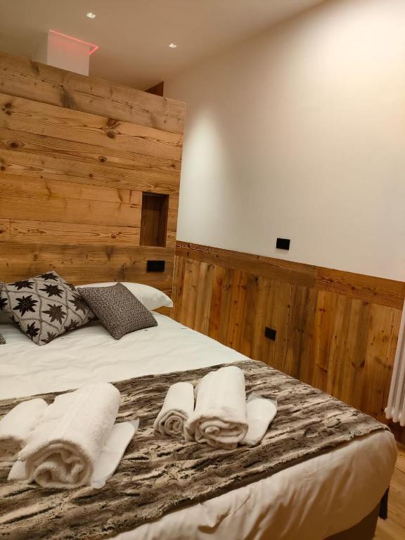 a bedroom with a large bed with towels on it at Fior di Roccia Apartments- in centro Cervinia, sauna privata, Matterhorn dream in Breuil-Cervinia