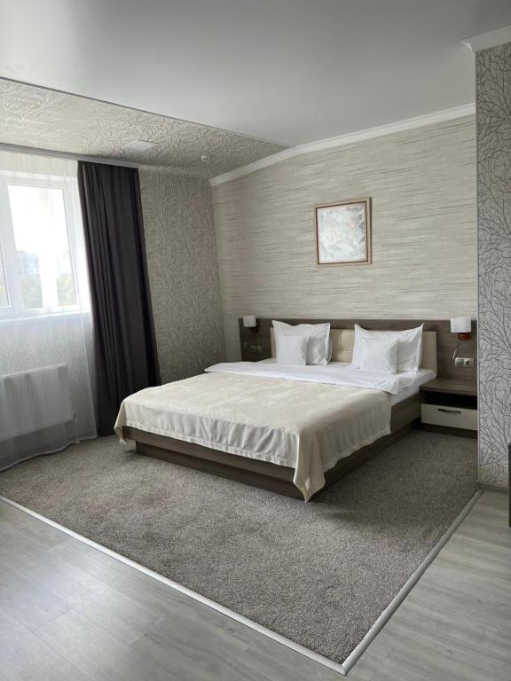 a bedroom with a large bed and a window at Elite Hotel in Bălţi