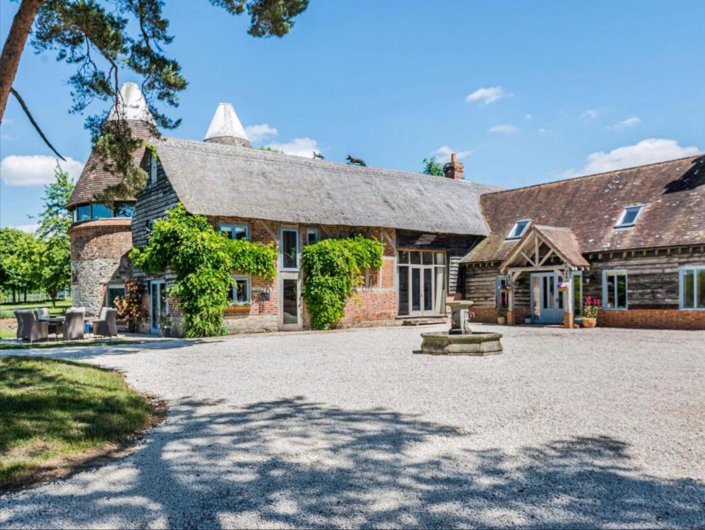 an old stone house with a large driveway at The Oast House - Hartley Wine Estate in Alton
