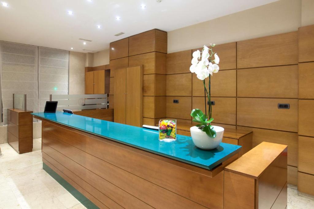 a kitchen with a blue counter with a vase of flowers at NH San Pedro de Alcántara in Marbella