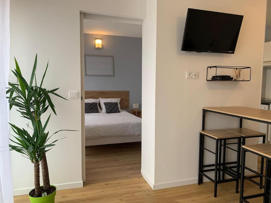 - une chambre avec un lit et une télévision murale dans l'établissement Bel appartement proche gare et centre-ville, à Rambouillet
