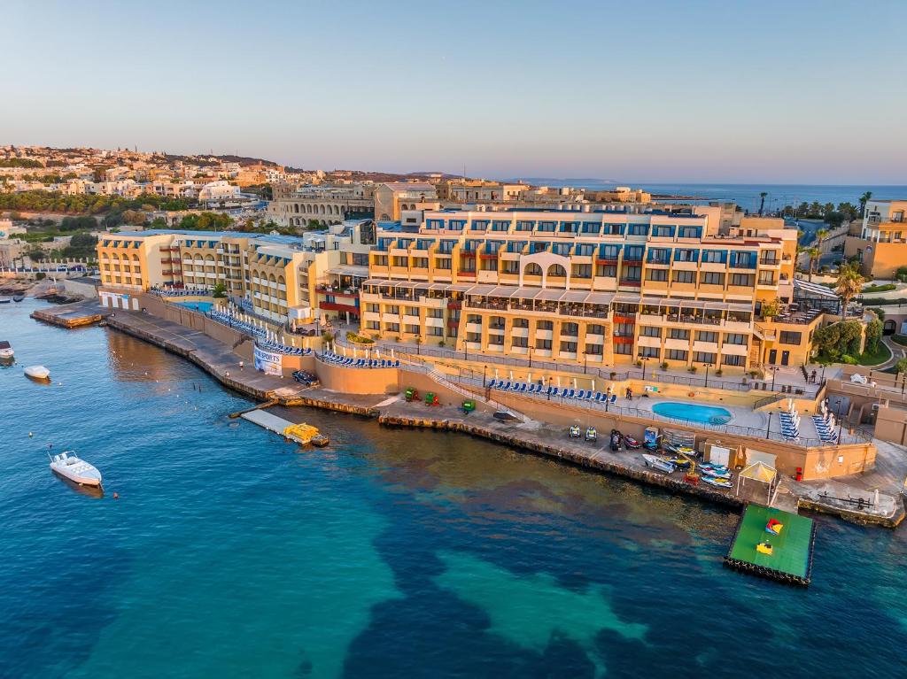 an aerial view of a city with buildings in the water at Marina Hotel Corinthia Beach Resort Malta in St. Julianʼs