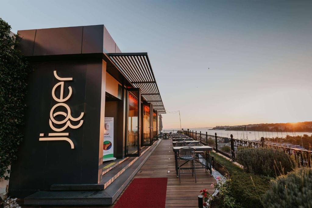 a building with tables and chairs on a boardwalk at Wyndham Grand Istanbul Kalamış Marina Hotel in Istanbul