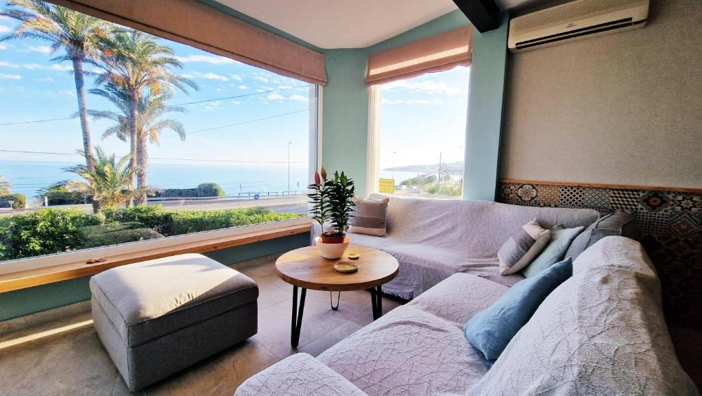 - un salon avec un canapé et une grande fenêtre dans l'établissement AA Guest - Mi Casa Eco Front Sea Views, à Mijas