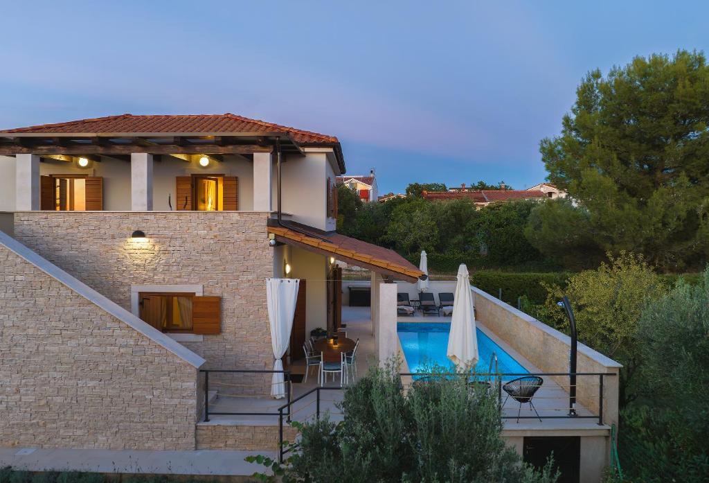 uma villa com uma piscina e uma casa em CASA MARE ISTRIA, villa with private pool, near the beach, with the sea view! em Peroj