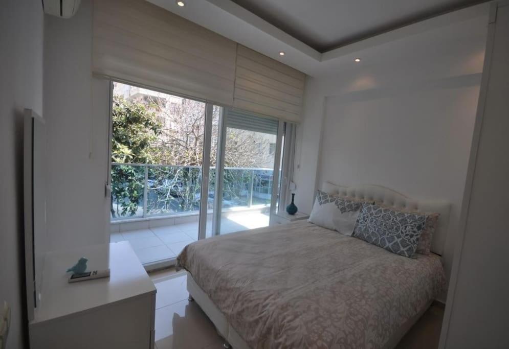 1 dormitorio con cama y ventana grande en Sun Homes: A Travellers Paradise, en Alanya