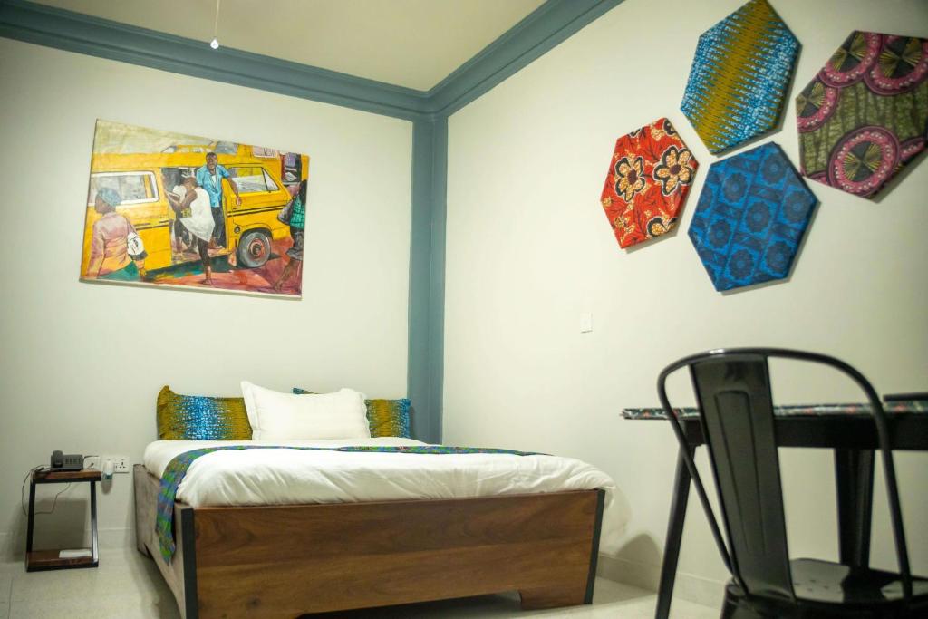 a bedroom with a bed and a painting on the wall at Heritage Hotels Arua in Arua